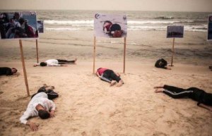 شبان فلسطينيون يجسدون مشهد الطفل &quot;ايلان&quot; على شاطئ غزة